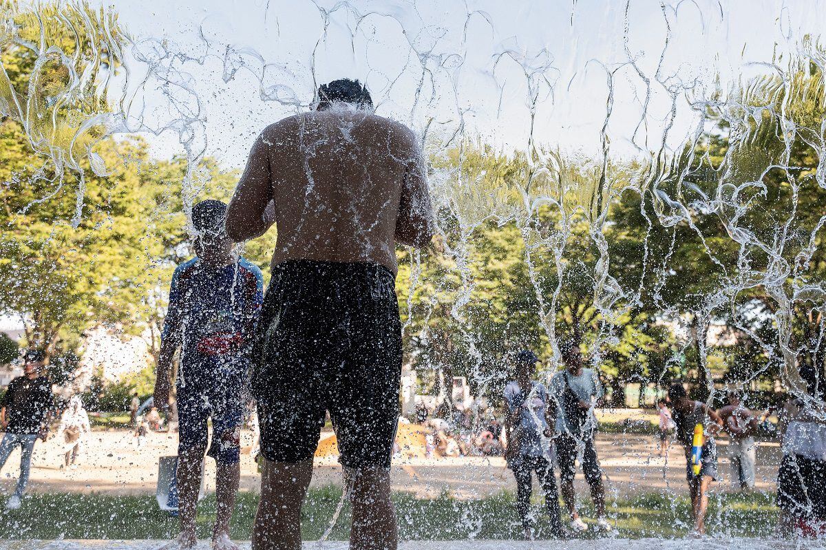 A man cools off in a public water park at a park in eastern Tokyo on July 16, 2023, as temperatures in the mid-30s Celsius.  (Photo by Richard A. Brooks / AFP)