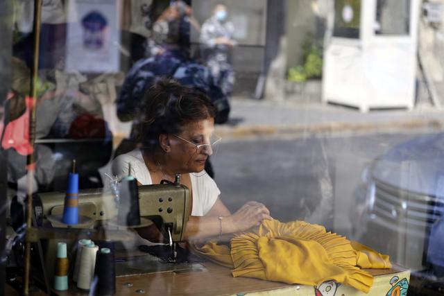 Claudette, una costurera libanesa de 60 años, trabaja en su tienda recién restaurada en el vecindario Gemmayzeh de Beirut, Líbano. (JOSEPH EID / AFP).