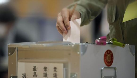 Un votante emite su voto en las elecciones de la cámara baja mientras representantes de una comisión de administración electoral local observan en un colegio electoral el domingo 31 de octubre de 2021 en Tokio. (Foto: AP / Eugene Hoshiko)