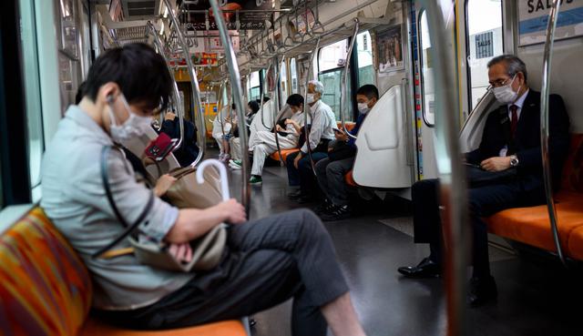 Las personas que usan máscaras faciales para protegerse del coronavirus (COVID-19) viajan en un tren en Tokio, Japón. (AFP / Behrouz MEHRI).