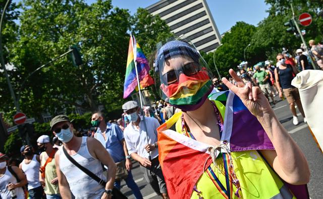 Un hombre con una máscara protectora, una medida contra la propagación de coronavirus,  con colores del arco iris participa en una Marcha del Orgullo en Berlín.  (Foto: AFP / TOBIAS SCHWARZ).