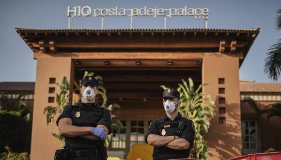 Policías con máscaras protectoras montan guardia frente al hotel H10 Costa Adeje Palace, en la isla canaria de Tenerife, España, que está en cuarentena por coronavirus. (Foto AP).