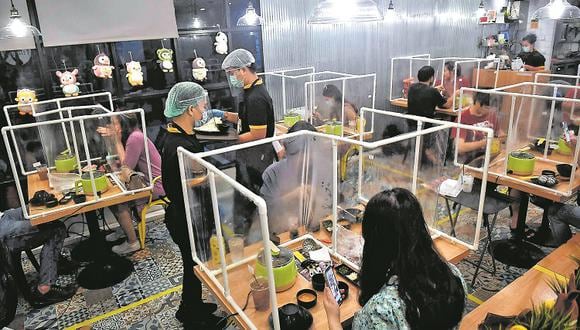 ¿Cómo será salir a comer? Penguin Eat Shabu hotpot, un restaurante en Bangkok, ha diseñado este sistema de separación de las personas por medio de plásticos ¿Podremos adaptarnos así en Perú? (Imagen: AFP)