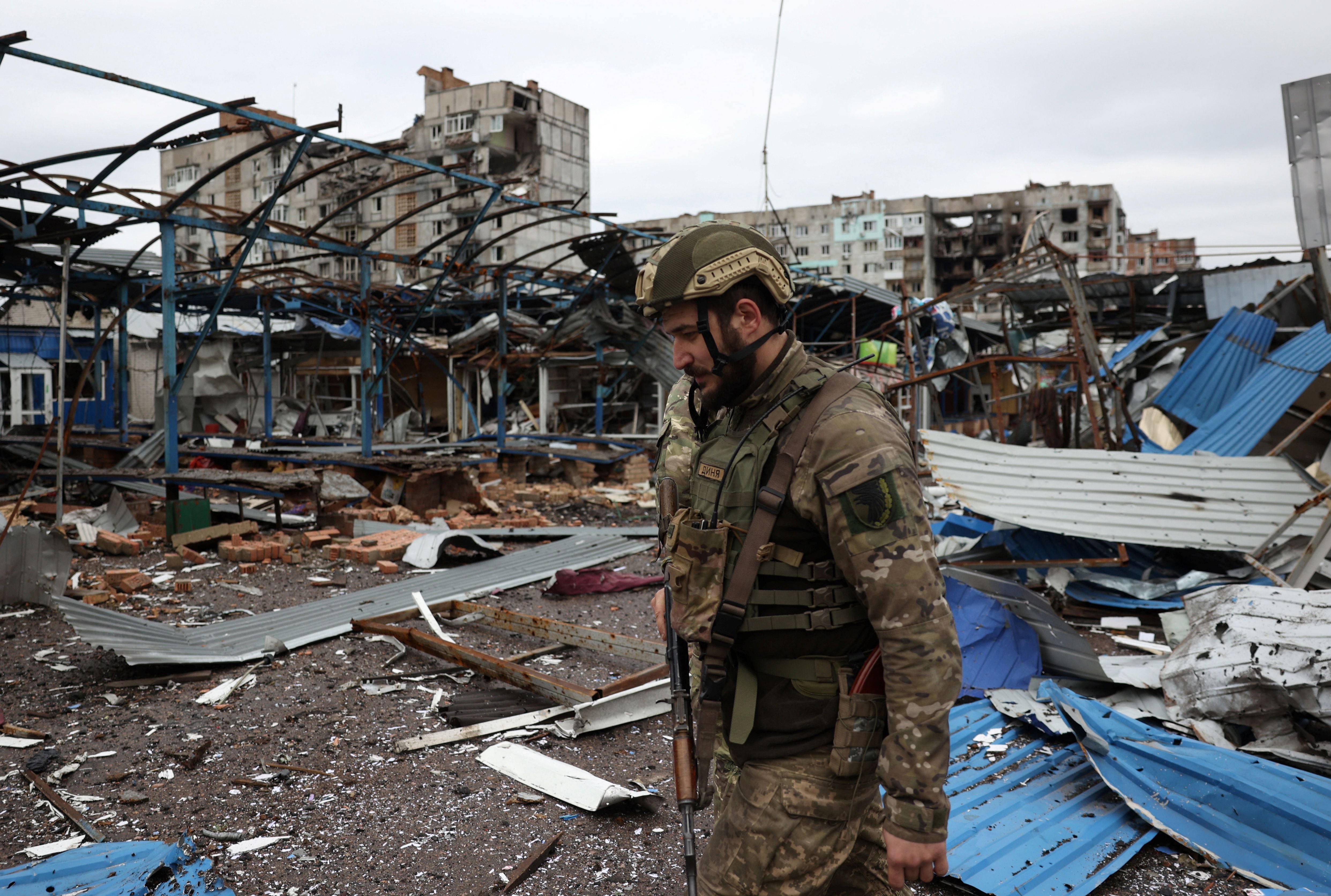 A Ukrainian serviceman walks near shell-damaged residential buildings in the town of Bakhmut, Donetsk region, on April 23, 2023. (Photo by Anatolii Stepanov / AFP)