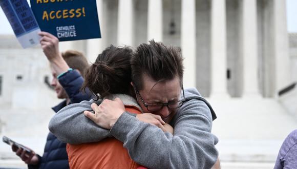 Jessica Golibart abraza a un manifestante frente a la Corte Suprema de EE. UU. en Washington, DC, el 3 de mayo de 2022. (Foto de Brendan SMIALOWSKI / AFP)