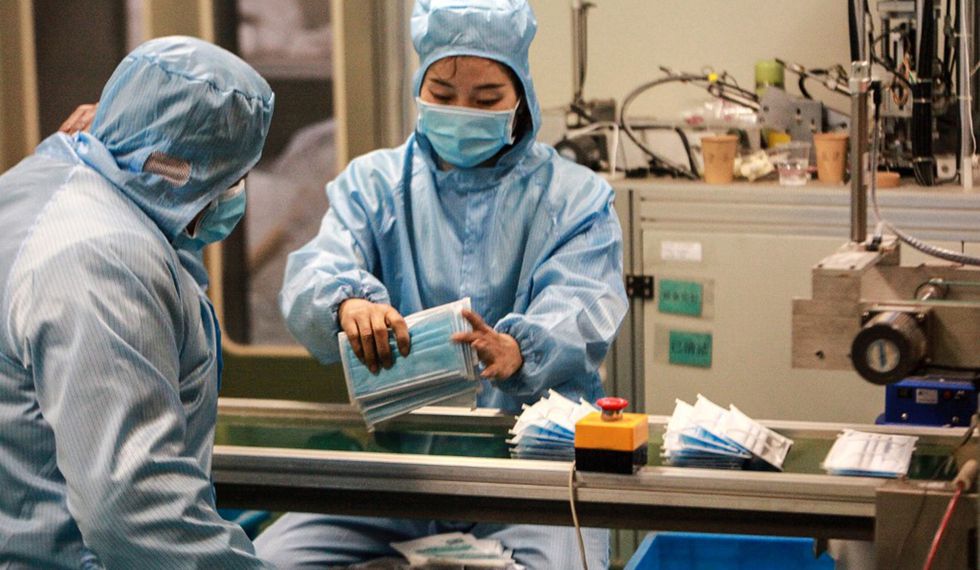 Trabajadores que producen máscaras faciales en una fábrica en Yangzhou, en la provincia oriental china de Jiangsu, para apoyar el suministro de materiales médicos durante un brote de virus mortal que comenzó en Wuhan. (Foto: AFP)