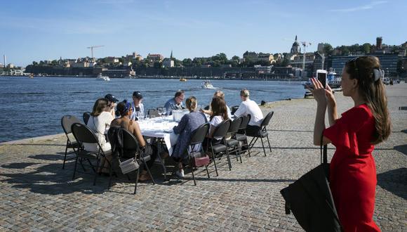 En esta imagen de archivo del viernes 26 de junio de 2020, empleados guardando la distancia social para beber algo tras trabajar, en Estocolmo, Suecia. (Stina Stjernkvist/TT News Agency via AP, Archivo).