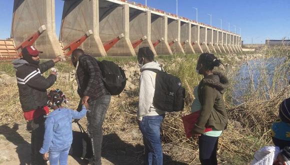 Un traficante mexicano lleva a una familia haitiana a través de la Presa Morelos sobre el río Colorado desde Los Algodones, México, hacia Yuma, Arizona. (Foto: AP /Elliot Spagat)
