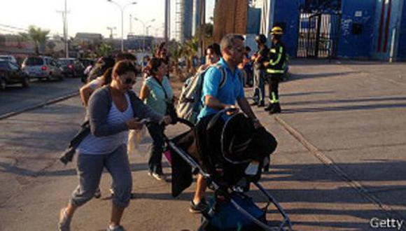 Una familia corre tras una alerta de tsunami en Iquique el pasado 16 de marzo.