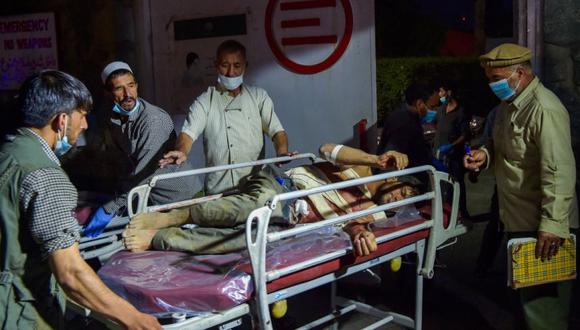 Personal médico y hospitalario lleva a un hombre herido en una camilla para recibir tratamiento después de dos poderosas explosiones fuera del aeropuerto de Kabul. (Foto: Archivo/ Wakil KOHSAR / AFP)