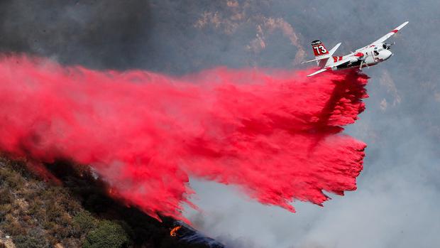 La función de los helicópteros o aviones es lanzar agua con productos químicos retardantes para ralentizar el fuego y dar más tiempo a los bomberos.