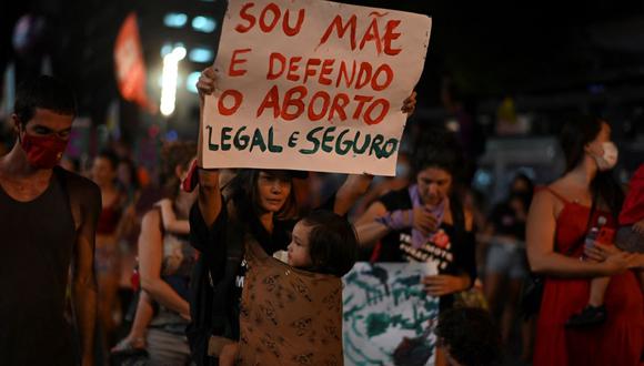 Una mujer sostiene un cartel en apoyo del aborto legal durante una manifestación para conmemorar el Día Internacional de la Mujer en el centro de la ciudad de Río de Janeiro, Brasil, el 8 de marzo de 2022. (MAURO PIMENTEL / AFP).