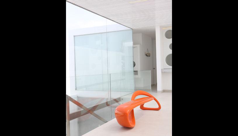 En un ambiente donde predomina el blanco, los acentos de color recaen en el mobiliario de líneas arquitectónicas, como la banca anaranjada del coleccionista Víctor Aburto. Foto: Jaime Gianella.
