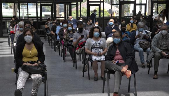 People wait to be inoculated with the Chinese CoronaVac vaccine against COVID-19 at a vaccination centre in Santiago, on March 16, 2021. - The vaccination campaign is about to surpass the barrier of 5 million people inoculated in Chile. (Photo by CLAUDIO REYES / AFP)