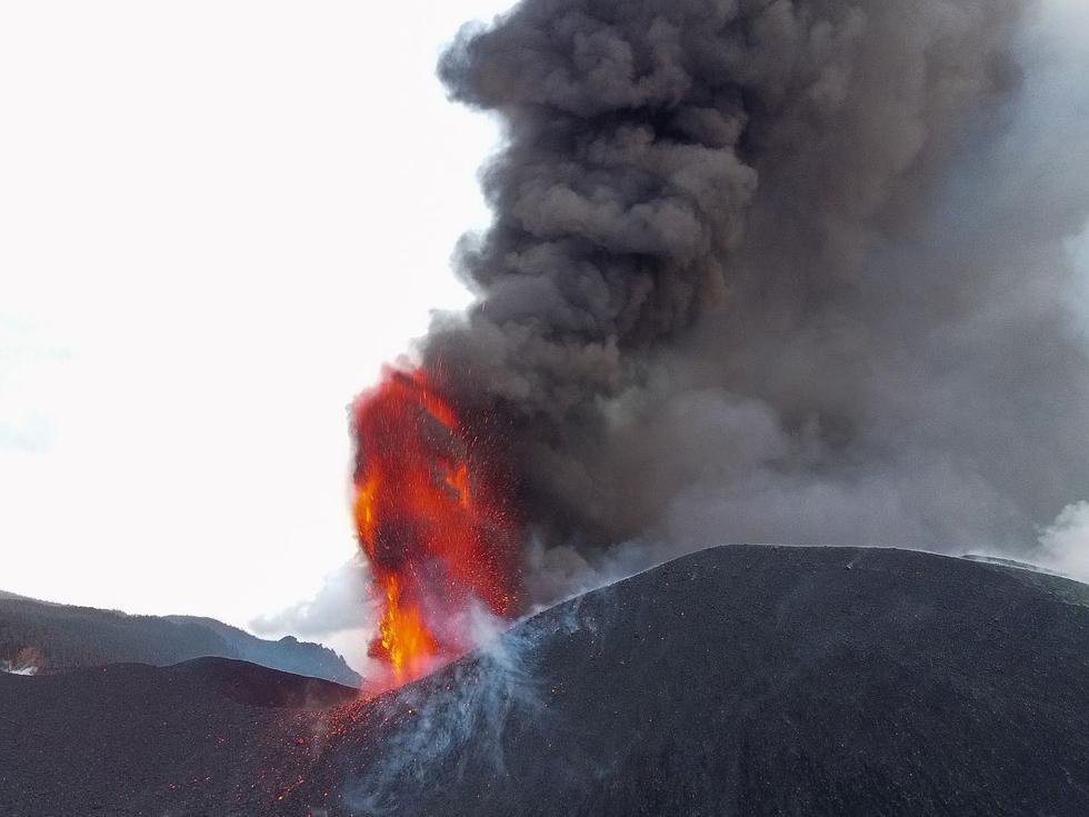 Esta fotografía tomada el 27 de octubre de 2021 muestra el volcán Cumbre Vieja arrojando lava, cenizas y humo, en Los Llanos de Aridane en la isla canaria de La Palma. (Víctor SVENSSON / AFP).