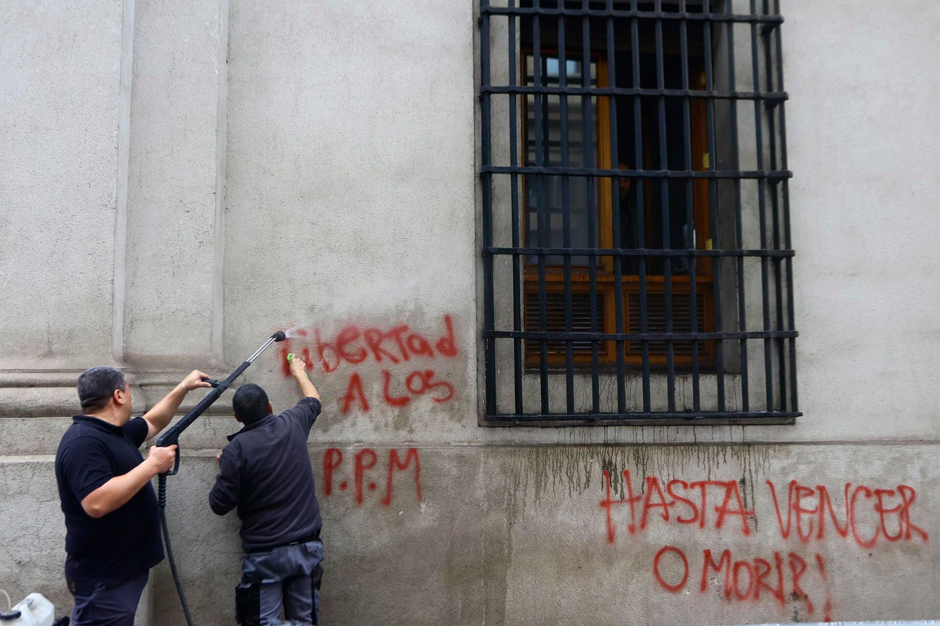 Cleaning staff clean the walls after a demonstration commemorating the 50th anniversary of the coup d'état against the democratic government of Salvador Allende in Chile.  (EFE/ Karin Pozo).