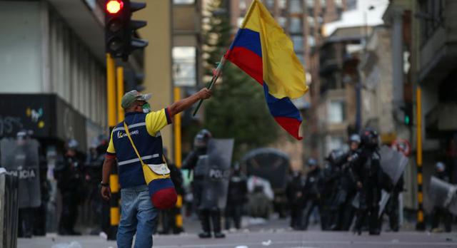 Un hombre sostiene una bandera de Colombia durante una protesta contra lo que los manifestantes dicen que es brutalidad policial en Bogotá, Colombia. (REUTERS / Luisa Gonzalez).
