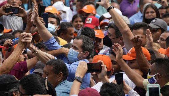 Los dirigentes opositores Juan Guaidó, al centro, y Freddy Superlano, a la derecha, saludan a manifestantes durante una protesta en apoyo al segundo en Barinas, Venezuela, el sábado 4 de diciembre de 2021. (Foto: AP /Ariana Cubillos)