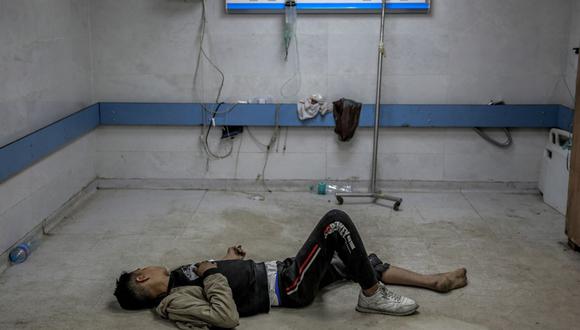 Un joven palestino herido en un bombardeo israelí yace en el suelo mientras espera atención médica en el hospital Al-Shifa en la ciudad de Gaza el 15 de marzo de 2024, en medio del conflicto en curso entre Israel y el movimiento palestino Hamas | Foto: AFP