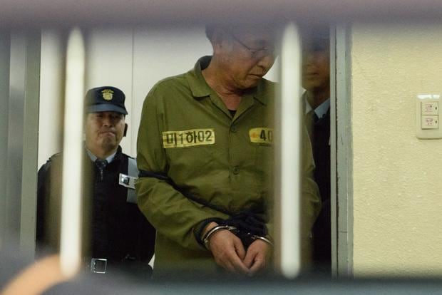 El capitán del ferry Sewol, Lee Jun-Seok, es escoltado después de llegar a un tribunal en Gwangju el 11 de noviembre de 2014. (Foto de ED JONES / AFP).