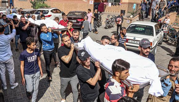 Los dolientes cargan los cuerpos de la familia Abu al-Rish, asesinado durante un ataque aéreo israelí en Khan Yunis, en el sur de la Franja de Gaza, durante su funeral el 12 de octubre de 2023 | Foto: SAID KHATIB / AFP