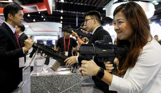 A visitor, right, tries out a Compact Personal Weapon (CPW) at the Singapore Airshow held at the Changi Exhibition Centre in Singapore, on Tuesday, Feb. 6, 2018. The air show runs through Feb. 11. Photographer: SeongJoon Cho/Bloomberg  Photographer: SeongJoon Cho/Bloomberg