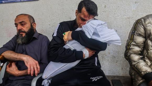 El padre palestino Ashraf llora mientras sostiene el cuerpo de una de sus dos hijas después de que ambas murieran en un ataque aéreo israelí nocturno en Rafah, al sur de la Franja de Gaza. (Foto de Mohammed ABED / AFP)