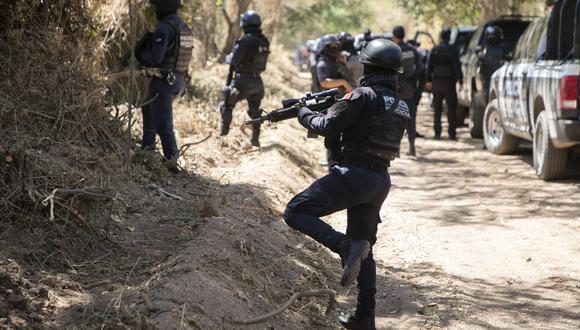 La policía federal  inspeccionando el terreno donde se halló un cuerpo sin vida, en Aguililla, estado de Michoacán, México, el 11 de marzo de 2022. (Foto de Enrique Castro / AFP)