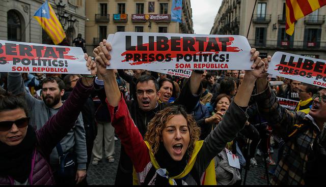 Demonstrators holding banners reading in Catalan "freedom for the political prisoners"  as they gather outside the Palau Generalitat during a general strike in Barcelona, Spain, Wednesday, Nov. 8, 2017. A worker's union has called for a general strike Wednesday in Catalonia. The regional government was sacked by Madrid and many of its members jailed in a rebellion probe after pushing ahead with secession from Spain. (AP Photo/Manu Fernandez)