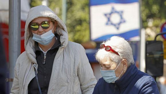 Israelíes que usan mascarillas protectoras debido a la pandemia de coronavirus compran en el mercado central de la ciudad costera de Netanya el 27 de diciembre de 2020. (Foto de JACK GUEZ / AFP).
