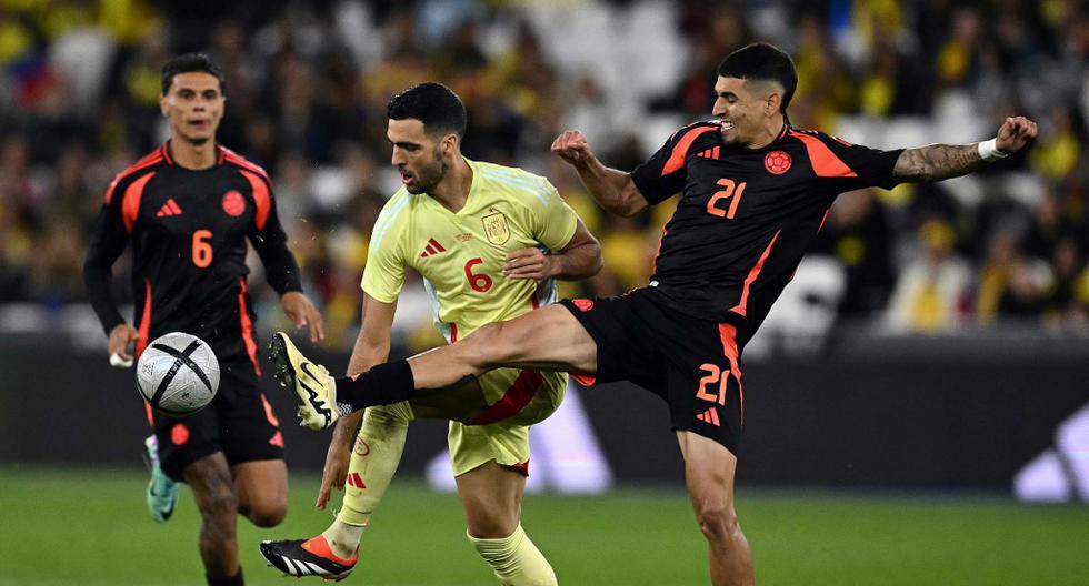 Colombia's defender #21 Daniel Munoz challenges Spain's midfielder #06 Mikel Merino during the international friendly football match between Spain and Colombia at The London Stadium in east London on March 22, 2024. (Photo by Ben Stansall / AFP)