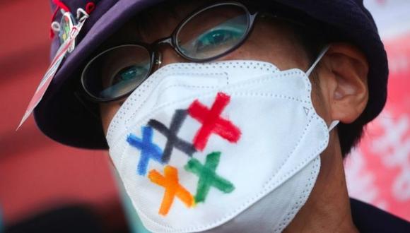 Un hombre lleva una mascarilla con los colores olímpicos en protesta contra los Juegos. (REUTERS)