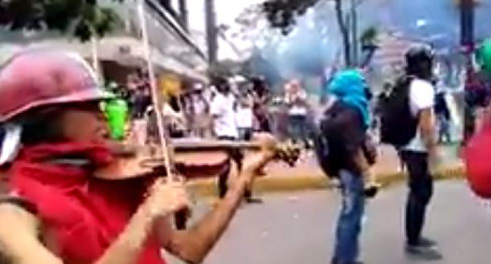 Este hombre toca el violín en medio de una caótica protesta en Venezuela. (Foto: Captura YouTube)