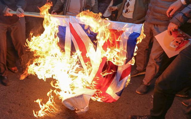 Manifestantes iraníes incendiaron la bandera británica frente a la embajada del Reino Unido en Teherán. (AFP / ATTA KENARE).