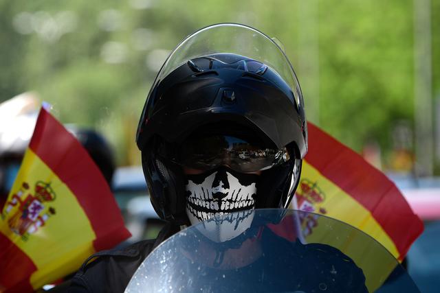 Un manifestante en su motocicleta participa en una "caravana por España y su libertad", protesta convocada por el partido de extrema derecha Vox contra el gobierno de Pedro Sánchez y sus medidas de confinamiento dictadas por la pandemia de coronavirus. (Foto por JAVIER SORIANO / AFP).