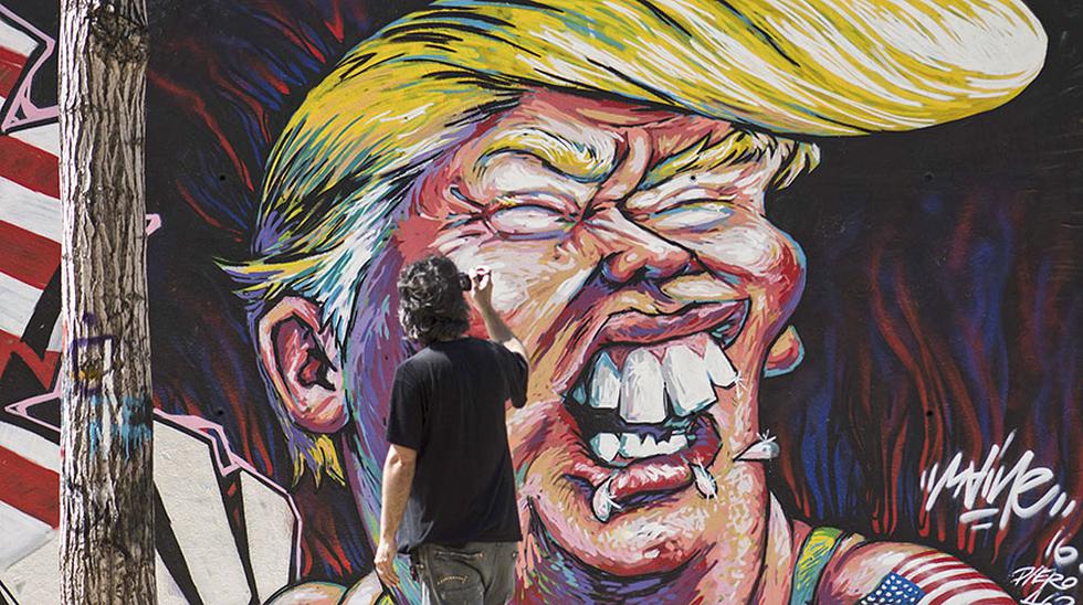 Un hombre toma las im&aacute;genes de un graffiti del candidato presidencial republicano Donald Trump en Barcelona. (Foto: AFP)