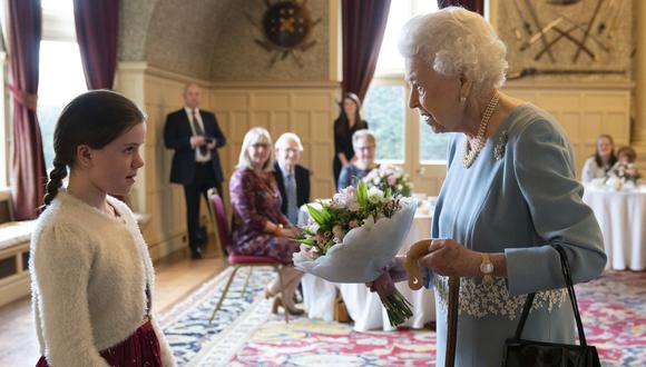La reina Isabel II recibe un obsequio de parte de Harriet Reeve, durante una recepción previa al Jubileo de Platino, en la casa Sandringham . Hoy. AP