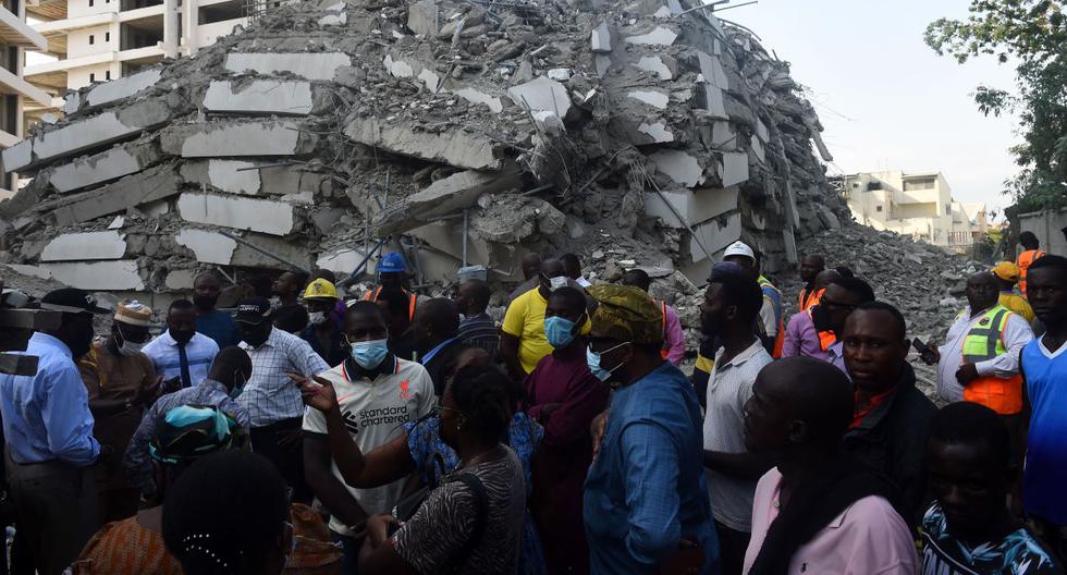 La gente está entre los escombros de un edificio de 21 pisos que se derrumbó en el distrito de Ikoyi, en Lagos, Nigeria, el 1 de noviembre de 2021. (PIUS UTOMI EKPEI / AFP).