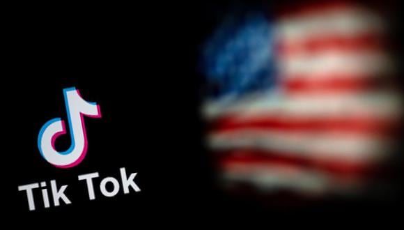 Esta ilustración fotográfica de archivo tomada el 14 de setiembre de 2020 muestra el logotipo de la aplicación de red social TikTok (izq.) y una bandera de los Estados Unidos (der.). (NICOLAS ASFOURI / AFP).