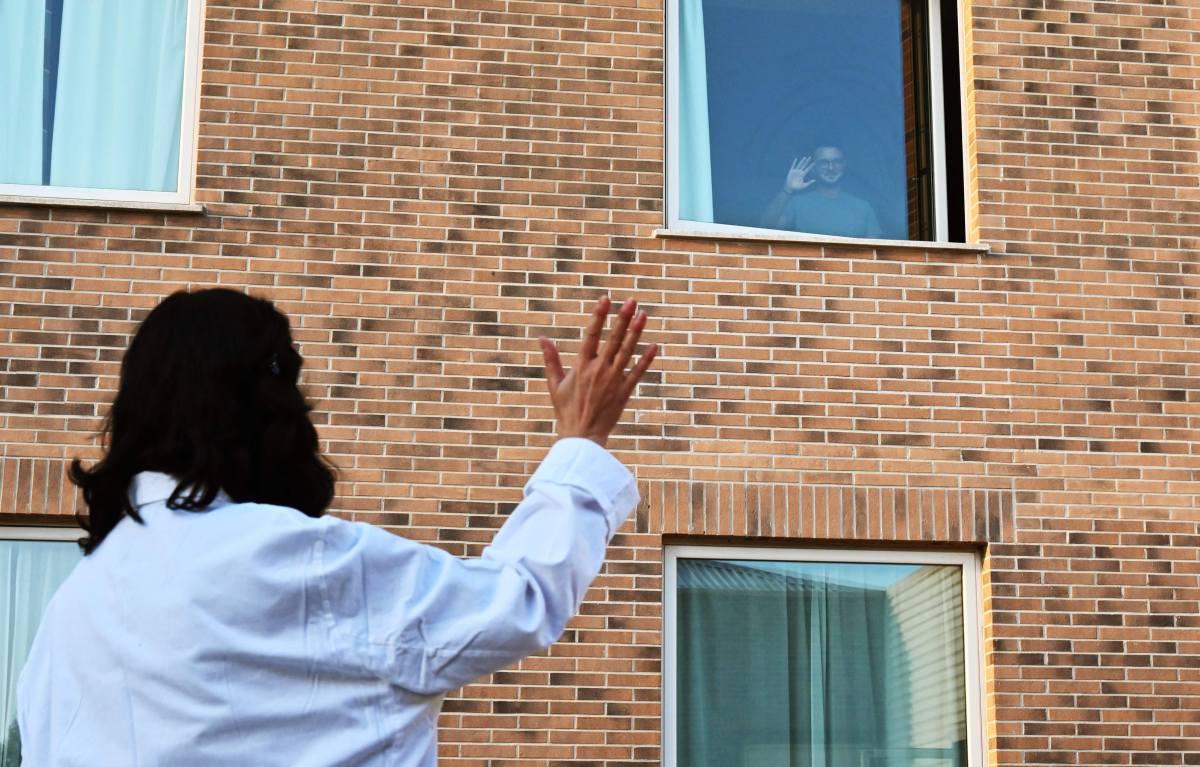 Un paciente saluda desde la ventana de su habitación en el Sheraton Parco de Medici de Roma, Italia, el 9 de noviembre de 2020. Los ciudadanos llegan a estas instalaciones de hospitales saturados por casos de coronavirus. (AFP / ANDREAS SOLARO).