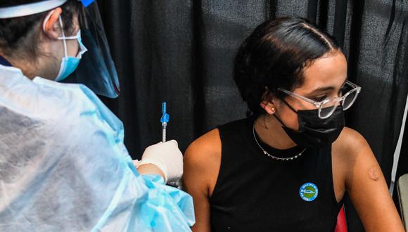 Un trabajador de la salud administra una vacuna contra el coronavirus Covid-19 a Valentina Jiménez, de 15 años, en Miami, Florida, el 5 de agosto de 2021. (Foto de CHANDAN KHANNA / AFP).
