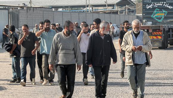 Los trabajadores palestinos, que quedaron varados en Israel desde los ataques del 7 de octubre, cruzan de regreso a la Franja de Gaza por el cruce fronterizo comercial de Kerem Shalom con Israel en el sur del enclave palestino el 3 de noviembre de 2023. (Foto de Mohammed ABED / AFP)