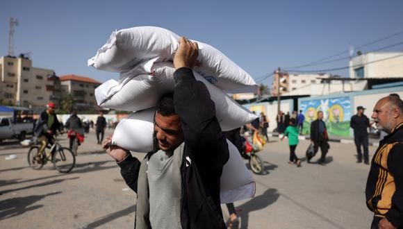 Un hombre lleva bolsas de ayuda humanitaria en Rafah, en el sur de la Franja de Gaza, el 26 de noviembre de 2023. (Foto de Mohammed ABED / AFP)