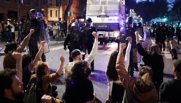 Los manifestantes se sientan y levantan el puño en el aire frente a la policía antidisturbios de CRS durante una manifestación después de que el gobierno aprobó una reforma de las pensiones en el parlamento sin votación, utilizando el artículo 49.3 de la constitución, en Toulouse, sur de Francia, el 28 de marzo de 2023 . (Foto de CHARLY TRIBALLEAU / AFP)