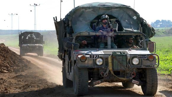 Una fotografía tomada desde una posición en el sur de Israel a lo largo de la frontera con la Franja de Gaza muestra tropas israelíes en vehículos militares el 4 de enero de 2024. (Foto de JACK GUEZ / AFP)
