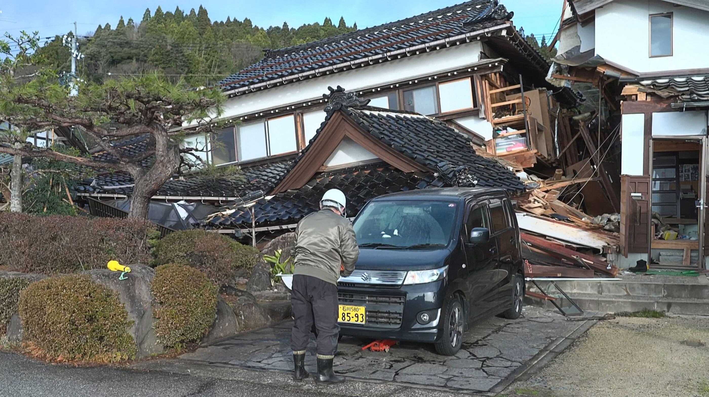 A man stands in front of a damaged house in Wajima, Ishikawa Prefecture, a day after a massive 7.6 magnitude earthquake hit Japan's Noto region.  (Photo by Fred Mery/AFPTV/AFP).