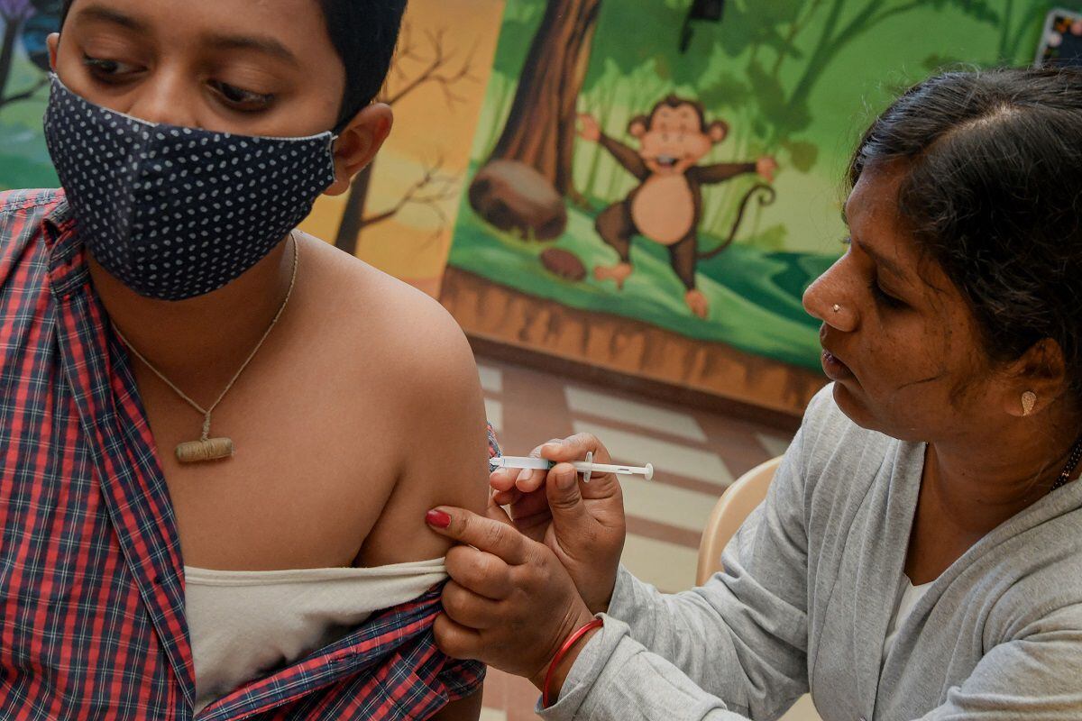 A health worker inoculates a school student with a dose of 'Corbevax' vaccine during a vaccination campaign for children in the 12-14 age group, in Bangalore on May 9, 2022. (Photo by Manjunath Kiran/AFP)