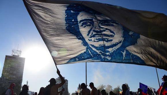 Un manifestante ondea una bandera con el rostro del músico chileno Víctor Jara durante una protesta contra el gobierno en Santiago el 15 de noviembre de 2019. (Johan ORDONEZ / AFP).