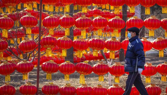 Un hombre que usa una mascarilla para protegerse del coronavirus pasa frente a una exhibición de linternas en un parque público en Beijing, el martes 5 de enero de 2021. China ha designado partes de la provincia de Hebei como zona de alto peligro de covid-19. (Foto AP / Mark Schiefelbein).