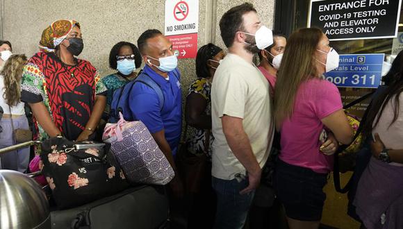 Decenas de pasajeros esperan en fila para obtener una prueba de coronavirus COVID-19 y poder viajar al extranjero en el Aeropuerto Internacional de Fort Lauderdale-Hollywood, Estados Unidos. (AP Foto/Marta Lavandier).